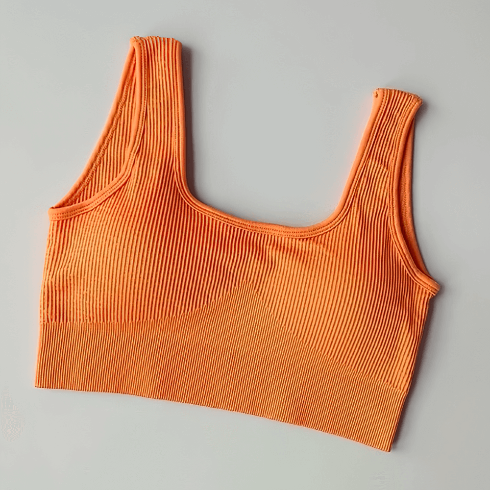 Orange seamless ribbed sports bra for women, crafted from breathable nylon and spandex, designed for support and style in workouts.